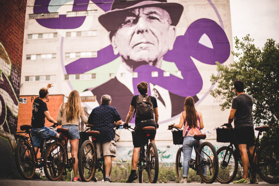 Montreal Bike tour in front of Leonard cohen graffiti. Mural